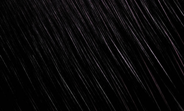 istock Slanting streams of rain on a black background. 1155096835