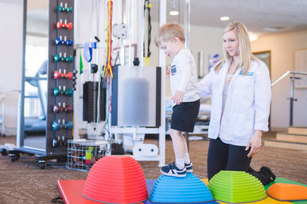 istock Physical therapist working with a young boy in the clinic 1155105478