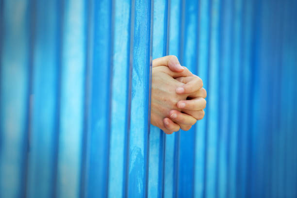 istock close up of hand in jail background. 1155105542