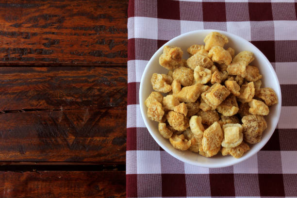 istock pork rinds (torresmo) fried in ceramic bowl on rustic wooden table in restaurant. typical dish of Brazilian and Asian cuisine 1155106271