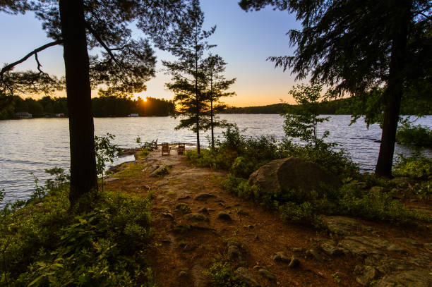 istock Adirondack chairs at sunset facing a lake 1155107597