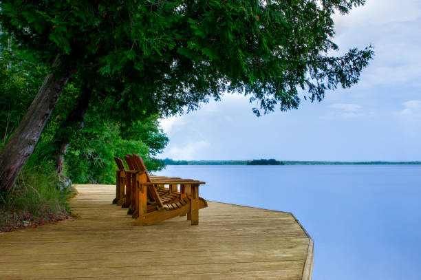 istock Adirondack chairs on a wooden pier 1155108103