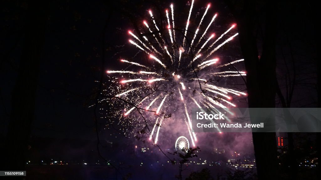 Fireworks over Niagara Falls The fireworks over Niagara Falls at night are a beautiful sight.  They usually have these displays on weekends over the water between Canada and the United States.  While they only last a brief time, the fireworks were magical and were the perfect ending to a day of awe. American Culture Stock Photo