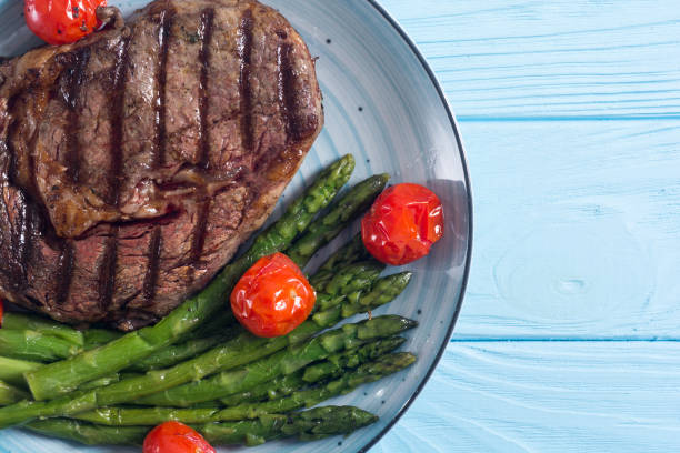 istock Grilled beef steak ribeye with cherry tomatoes and asparagus 1155110102