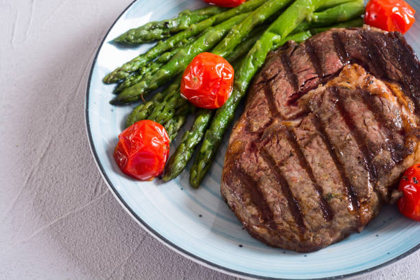istock Grilled beef steak ribeye with cherry tomatoes and asparagus 1155110360