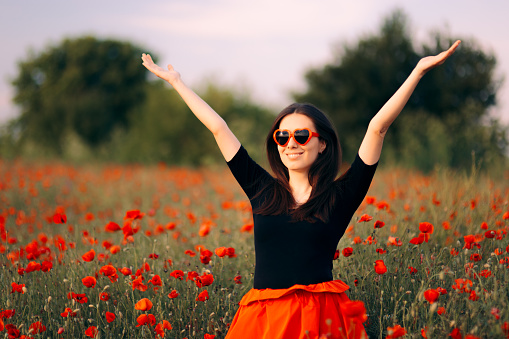 Relaxed girl having fun in summer outdoors in a flower field