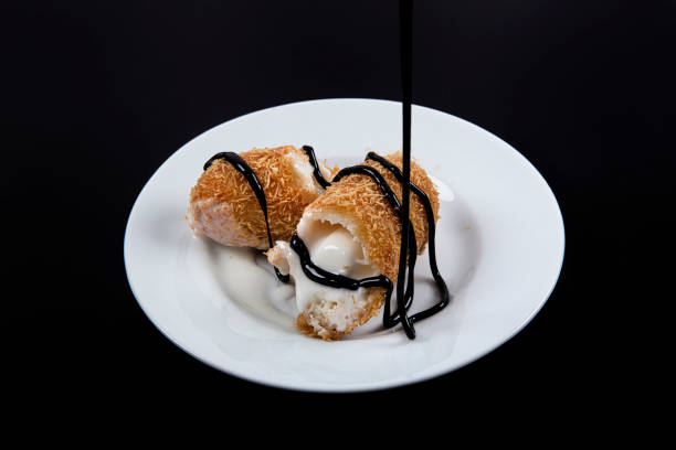istock Delicious Turkish dessert. Fried ice-cream covered with chocolate Kadayif. Turkish name; ''Kadayif kapli kizarmis dondurma''. 1155111410