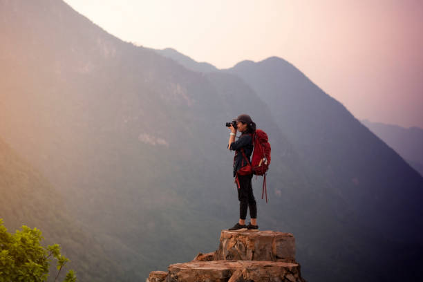 istock Backpacker woman take photo on peak mountain 1155112787