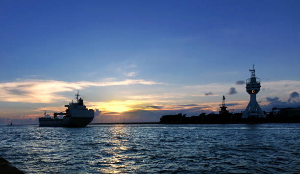 istock Cargo Ship Leaves Port at Dusk 1155115526