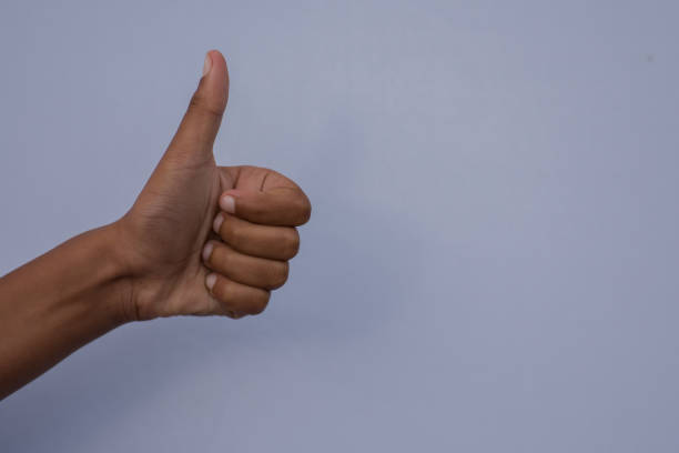 istock Thumbs up gesture against blue background 1155120460