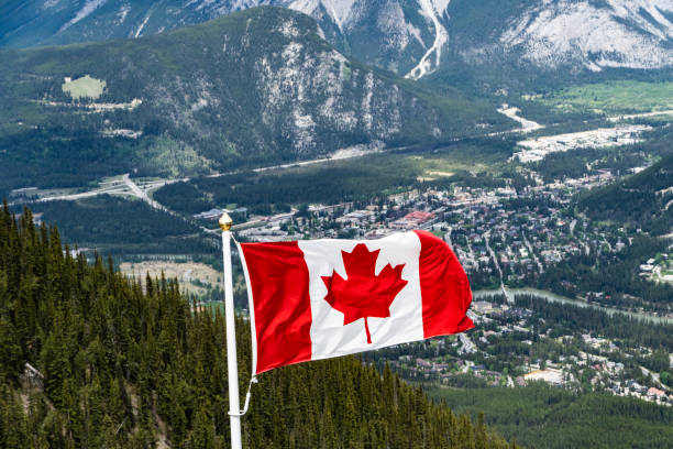 istock Canadian Maple Leafe Flag flying over mountains 1155123957