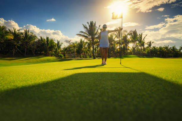 golfeur de jeune femme restant sur le terrain de golf tropical en république dominicaine - sports flag golf individual sports sports and fitness photos et images de collection