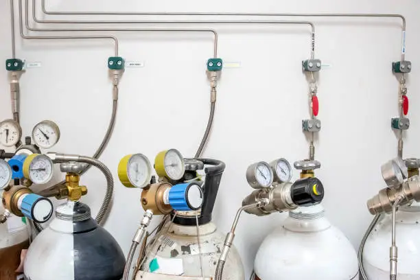 Valves of nitrogen, Helium, Oxygen ( Air Zero) tank and Gas Pressure Meter with Regulator for monitoring measure pressure production process in Chemistry Laboratory room