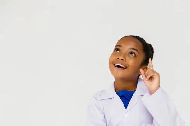 Photo of Young preteen African American kid wearing lab coat thinking