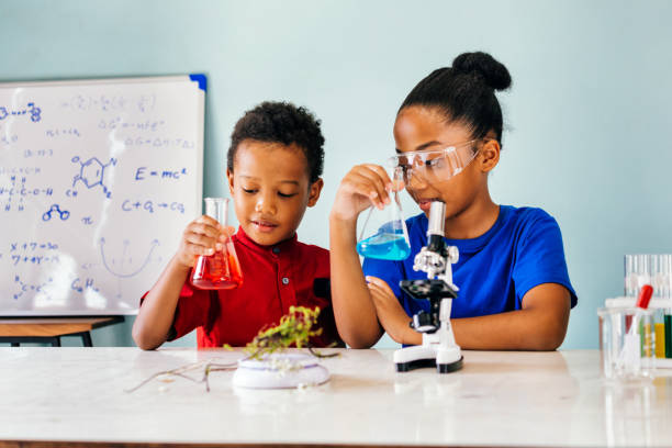 Happy kids with flasks in school chemistry laboratory stock photo