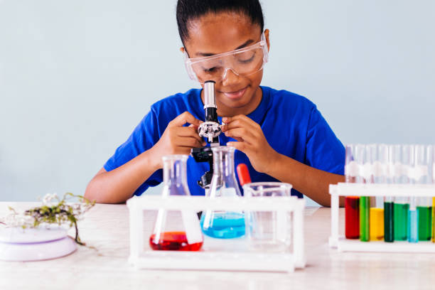 miúdo do americano africano que olha no microscópio no laboratório - colors liquid small laboratory - fotografias e filmes do acervo