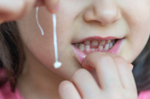 istock Girl holding lost milk tooth 1155137519