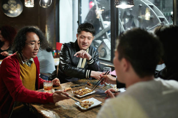 gruppe japanischer männer, die sich bei dinner im restaurant tokyo verfreuten - eating men food chopsticks stock-fotos und bilder