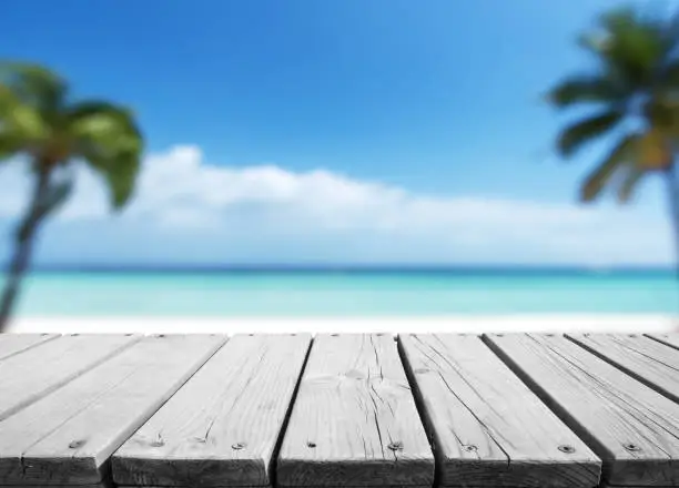 Photo of Empty wooden platform with blurred tropical beach background