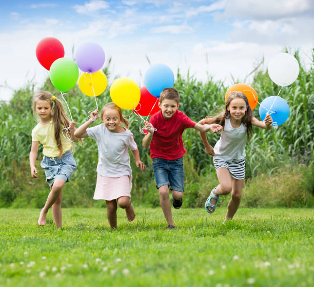 istock Four kids running on green lawn 1155138737