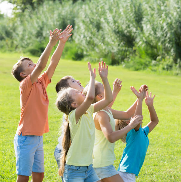 istock smiling kids jumping together in park on summer 1155138905