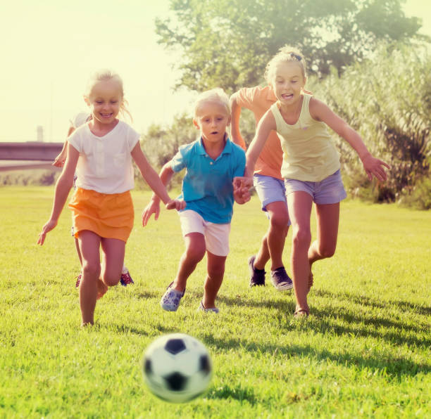 istock children playing football on meadow 1155139676