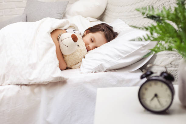 istock Cute little child girl sleeping with teddy bear 1155142751