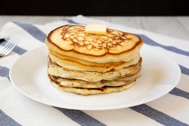 istock Homemade pancakes with butter on a white plate, side view. Close-up. 1155143734