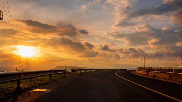 istock mountain view and road with sunset golden sky 1155146017