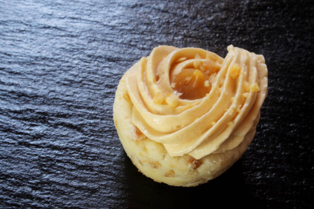istock Mini caramel tart on black stone background 1155146182