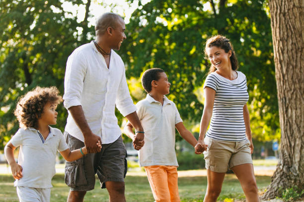 istock Happy couple spending time with their sons in the park 1155150038