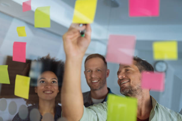 istock Coworkers discussing new ideas on a glass wall 1155150909
