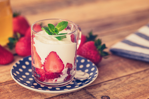 Fruit yogurt with fresh strawberries, close up