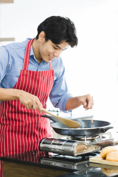 istock Asian man fried hamburger in pan on stove. 1155152376