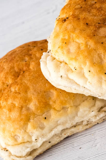 istock Crusty Bread Rolls on a White wooden Board 1155152508