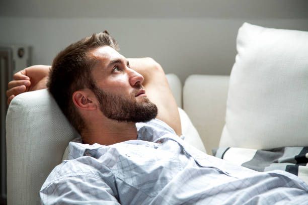 istock Attractive man with a beard is relaxing on a couch 1155152544