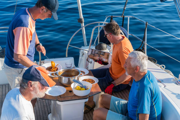 istock Four men having Chili con carne on sailing boat 1155152621