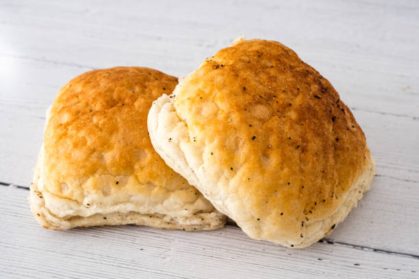 istock Crusty Bread Rolls on a White wooden Board 1155152727