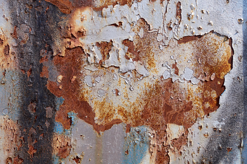 Detail of corroded rusty barrel metal texture that is red white and blue