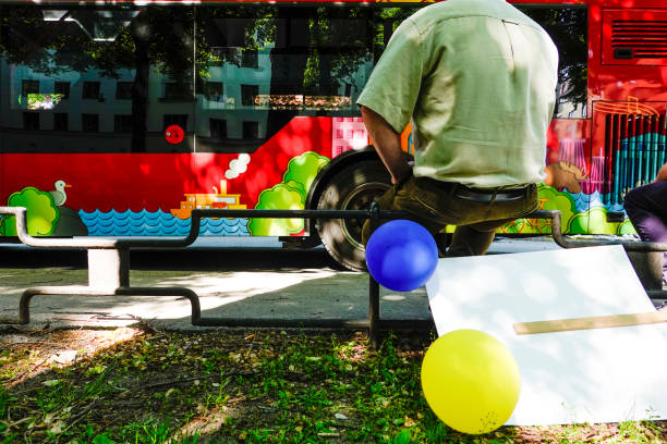 Stockholm, Sweden Stockholm, Sweden June 10, 2019 A man sits on a fence with balloons during a high school graduation ceremony. studenten stock pictures, royalty-free photos & images