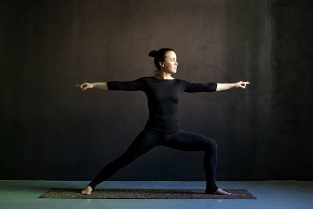 istock Young woman practicing yoga Warrior pose, Virabhadrasana. 1155154276