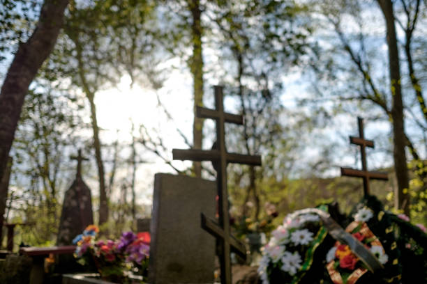 Blurred grave cross on the Orthodox Christian cemetery at sunny day in Russia. Out of focus.