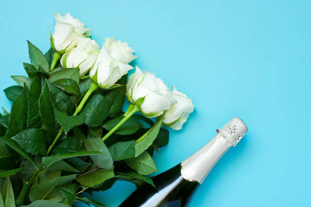 Champagne bottle and roses  bouquet Celebration background - top view of  champagne  bottle and roses bouquet. Copy space, top view valentinstag stock pictures, royalty-free photos & images