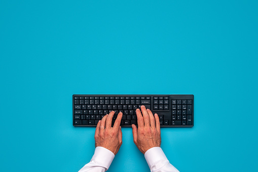 Manos masculinas usando el teclado de computación negro photo