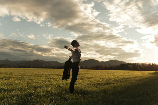 istock Businessman standing in nature with arms wide open 1155157381