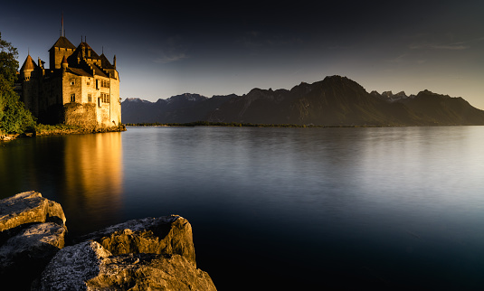 Montreux, VD / Switzerland - 31 May 2019: the historic Chillon Castle on the shores of Lake Geneva at sunset