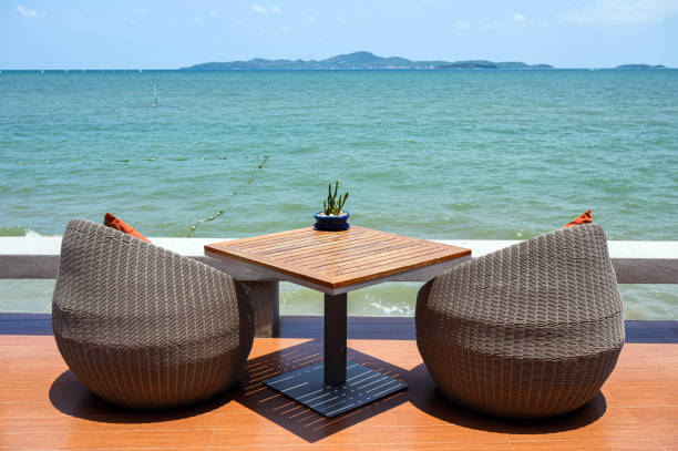 istock Modern weave chairs with wooden table with tropical sea 1155162534