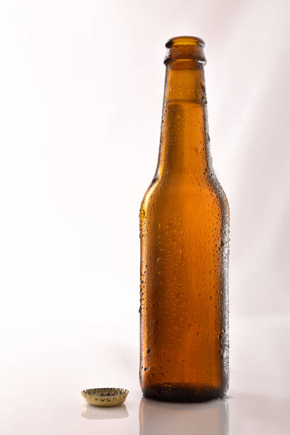 istock Beer bottle filled and open on glass table black background. 1155163379