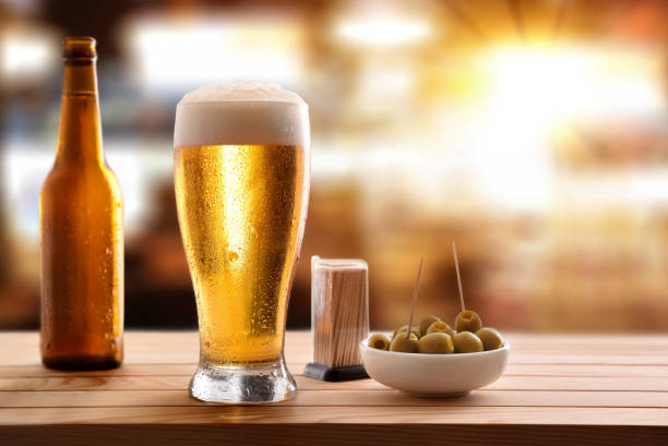 istock Appetizer with glass beer on wooden slatted table in pub 1155163397