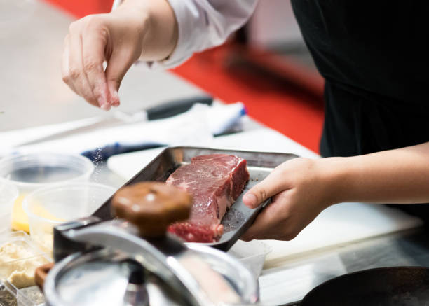 istock Chef salt and pepper meat  beef steak, cooking meat steaks on kitchen 1155163763